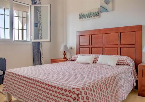 1 dormitorio con 1 cama con manta roja y blanca en Apto Julia, 1ª Línea de Playa y Vistas al Mar, en Mojácar