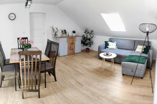 a living room with a blue couch and a table at Zielony Zakątek - agroturystyka blisko morza in Kierzkowo