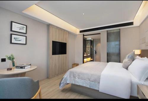 a bedroom with a bed and a desk and a tv at Morning Hotel, Liuyang Country Garden Municipal Government in Liuyang