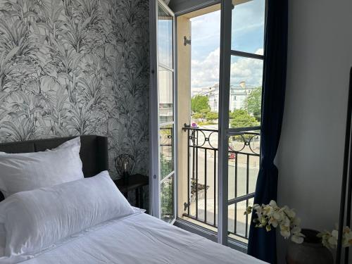 a bedroom with a bed next to a balcony at Appt Vue Place de Toscane - 4min Disneyland-PARIS in Serris