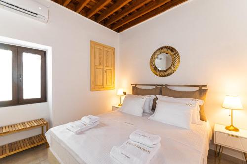 a bedroom with a large white bed with two towels at Villa Danae - Lindos in Lindos