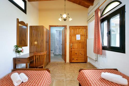 1 Schlafzimmer mit 2 Betten, einem Schreibtisch und einer Tür in der Unterkunft Villa Kapasa in Mathés