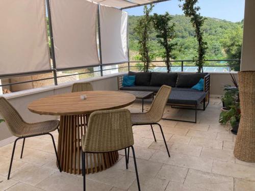 een patio met een tafel en stoelen en een bank bij House Roki in Vis