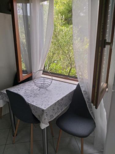 a table and two chairs in a room with a window at Direkt na moru - Bungalov in Šibenik