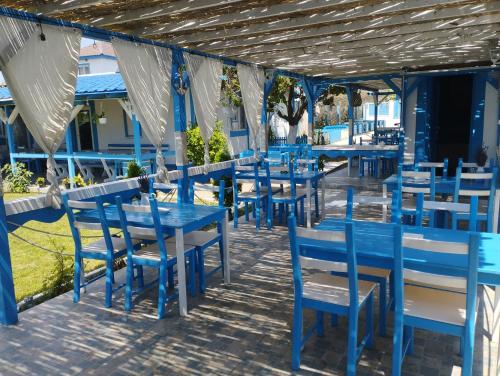 una fila de mesas y sillas azules en un restaurante en Pensiune Blue Coral Jurilovca, en Jurilovca