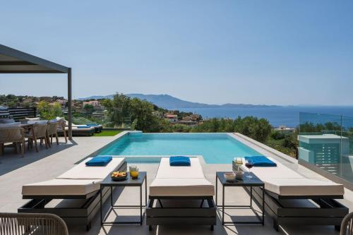 a pool with tables and chairs next to a swimming pool at Villa Ekphrasis with sea view and jacuzzi in Ravdhoúkha