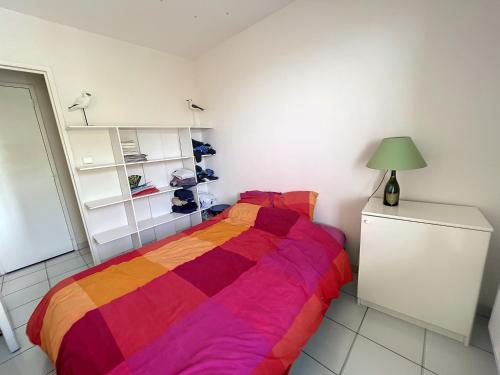 ein Schlafzimmer mit einem Bett mit einer bunten Decke in der Unterkunft Appartement Granville, 2 pièces, 2 personnes - FR-1-361-440 in Granville