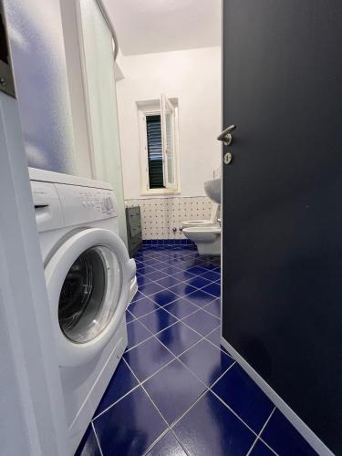 een badkamer met een wasmachine en een toilet bij Cataleya Baia del Carpino Scalea in Scalea