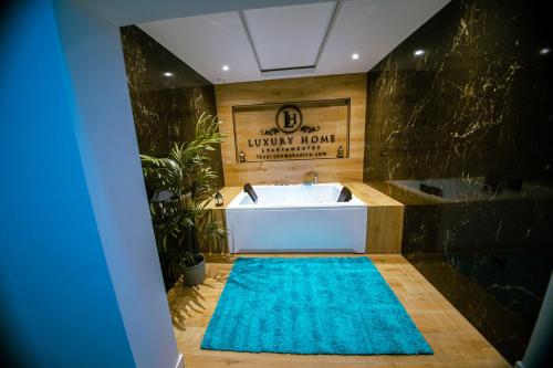 a bathroom with a bath tub and a blue rug at LUZ DE PATIOS in Huelva