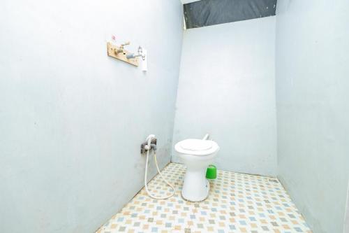 a bathroom with a white toilet in a room at Chikar Glamping At Wisata Coban Talun Mitra RedDoorz in Junggo
