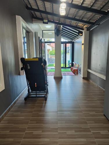 a room with a hallway with a floor with wooden floors at Ammara Homestay in Pasir Gudang