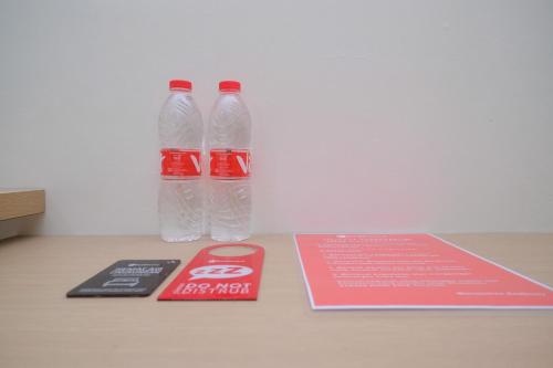 two bottles of water and a book on a table at RedDoorz near Kawasan Bandara Ahmad Yani Semarang 2 in Kalibanteng-kidul