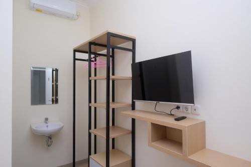 a television on a shelf in a room at RedDoorz near Kawasan Bandara Ahmad Yani Semarang 2 in Kalibanteng-kidul