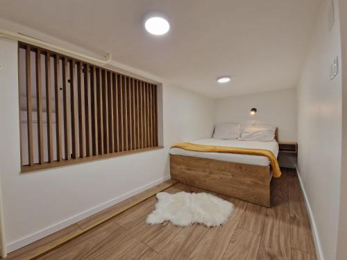 a bedroom with a bed and a window and a rug at Apartman Gallery in Slavonski Brod