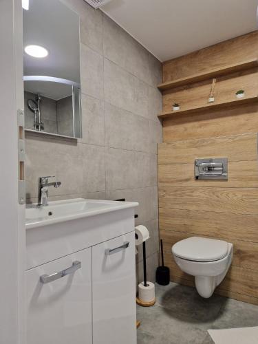 a bathroom with a white sink and a toilet at Apartman Gallery in Slavonski Brod