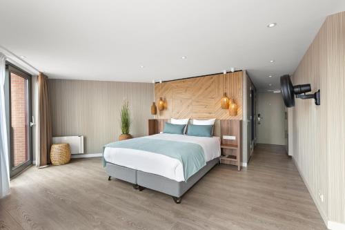 een slaapkamer met een groot bed met blauwe kussens bij Suites Boulevard 17 in Vlissingen