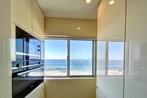 una cocina con vistas al océano desde una ventana en Apartamento Luxo T3 Vista Mar-Tritão, en Vila do Conde