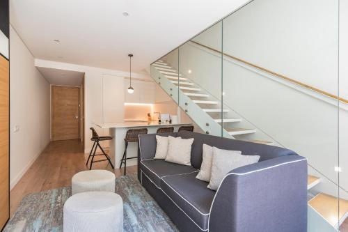 a living room with a couch and a staircase at Hyatt Regency Lisbon in Lisbon