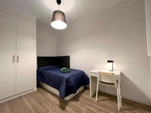 Schlafzimmer mit einem Bett, einem Schreibtisch und einem Tisch in der Unterkunft Excelente piso en barrio Salamanca! in Madrid