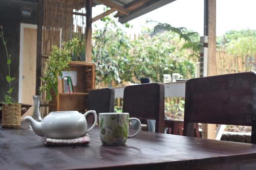 a table with a tea pot and cups on it at Mama's Homestay Ruteng in Ruteng