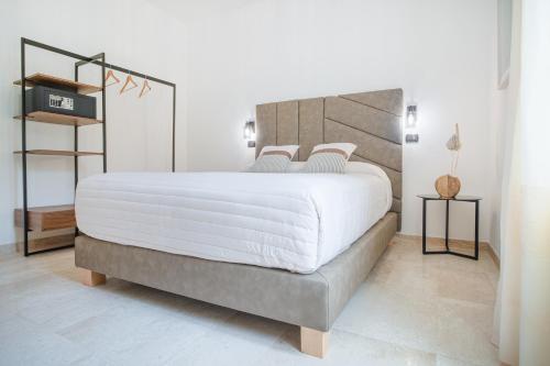 Paghe Eco Luxury Experience في Buddusò: غرفة نوم بسرير كبير مع شراشف بيضاء