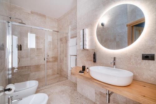 y baño con lavabo blanco y espejo. en Paghe Eco Luxury Experience, en Buddusò