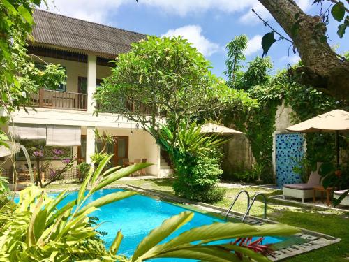 a swimming pool in front of a villa at Villa Puriartha Ubud - CHSE Certified in Ubud