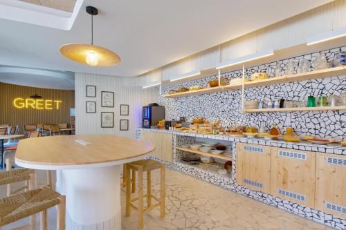 a restaurant with a table and a counter with food at greet hotel Salon de Provence in Salon-de-Provence