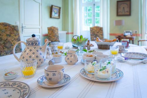 einen Tisch mit Geschirr und eine Teekanne drauf in der Unterkunft Château Laborde Saint Martin in Candé-sur-Beuvron