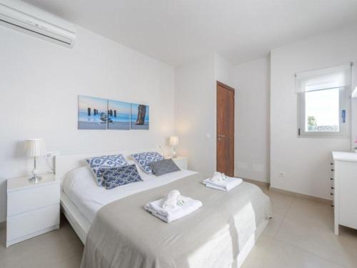 ein weißes Schlafzimmer mit 2 Betten und Handtüchern darauf in der Unterkunft Moderna casa con piscina privada in Santa Eulària des Riu