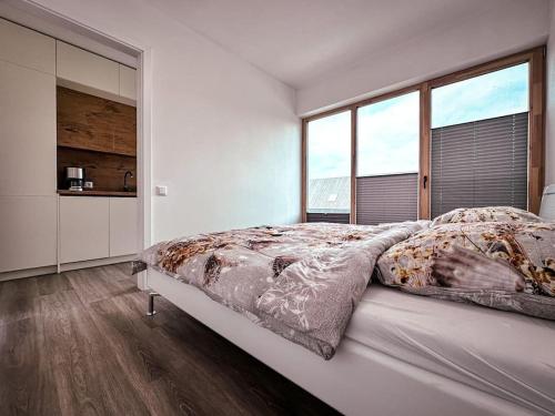 a white bedroom with a large bed and large windows at Sea Breeze Solitude in Svencelė