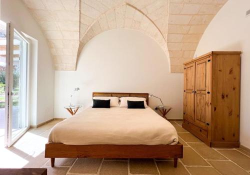 a bedroom with a large bed and an arched ceiling at Villaria Luxury apulian villa with pool in Campomarino