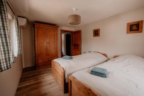 a bedroom with two beds and a wooden floor at Gîte du Fronholz - Maison alsacienne avec jardin et service traiteur in Epfig