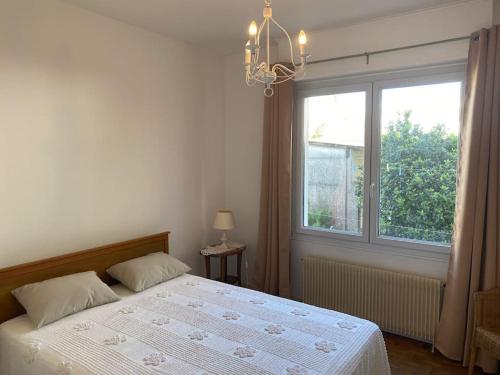 une chambre avec un lit et une grande fenêtre dans l'établissement La teste centre-ville mourillat, à La Teste-de-Buch