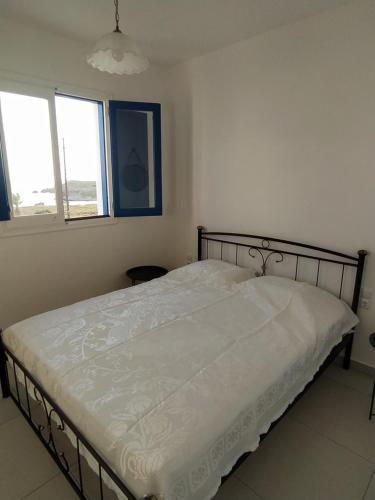 a bedroom with a bed in a room with two windows at Central New Fully Furnished Apartments in Karpathos,Lefkos in Lefkos Karpathou
