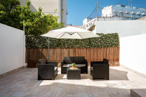 a patio with chairs and a table with an umbrella at Lisbon Zoo House III in Lisbon