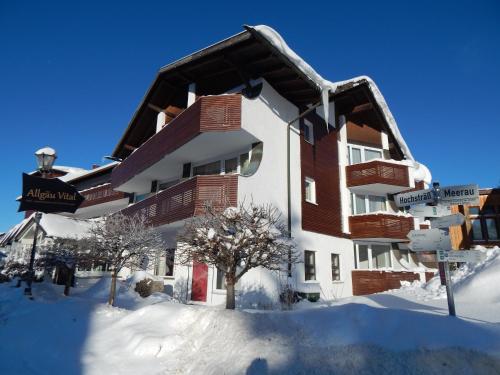 ein großes Gebäude mit Schnee auf dem Boden in der Unterkunft Vital Lodge Allgäu mit Oberstaufen PLUS in Oberstaufen
