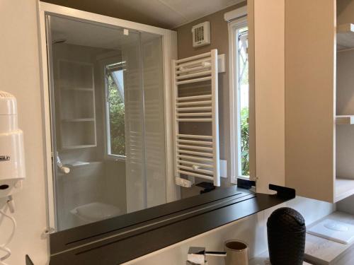 a bathroom with a glass shower with a mirror at Le Domaine des Pins in Saint-Hilaire-de-Riez