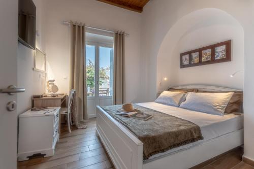 a bedroom with a large bed and a window at Venetian Suites III in Naxos Chora