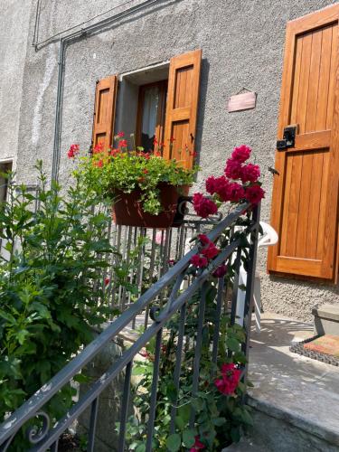 a house with flowers on a railing and a window at Casa Vacanze Ca' di Lucchini in San Benedetto Val di Sambro