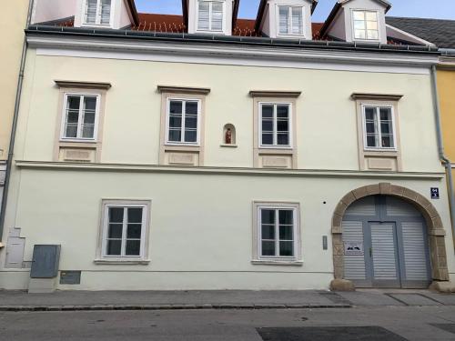 un edificio blanco con puerta y ventana en Paky Appartements 00316, en Bruck an der Leitha