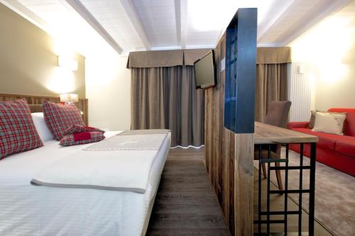a hotel room with a bed and a tv at Olimpia Hotel in Bormio