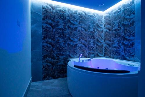 Habitación azul con baño con bañera. en Royal Playa Suite and Apartament -private parking-, en Catania