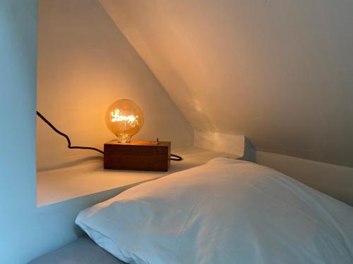 una camera da letto con un letto con una lampada sopra di La folie douce, maison d'hôtes 