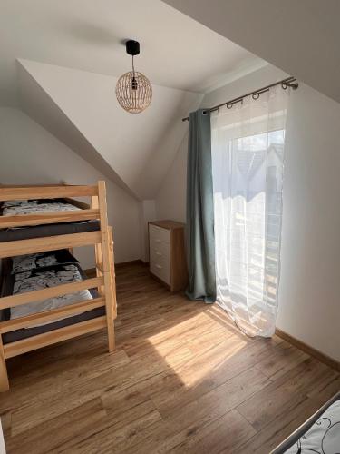 a room with a bunk bed and a window at Piaski Morza A in Gąski