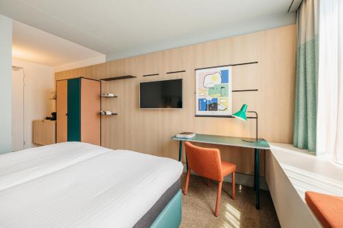 Cette chambre comprend un lit et un bureau. dans l'établissement Hotel Casa Amsterdam, à Amsterdam