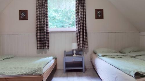 two twin beds in a room with a window at Iskierkówka in Brenna