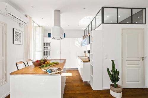 - une cuisine avec des murs blancs et un comptoir en bois dans l'établissement La Cachette du Port! -Avec parking au Port de Nice, à Nice