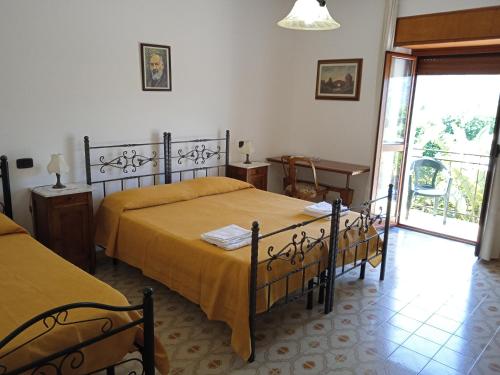 カパッチョ・ペストゥムにあるB&B La Porta Del Cilentoのベッドルーム1室(ベッド2台、窓付)