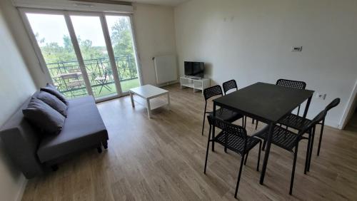 een woonkamer met een tafel en stoelen en een bank bij Flat for 6 persons 10 minutes from CDG Airport in Le Blanc-Mesnil